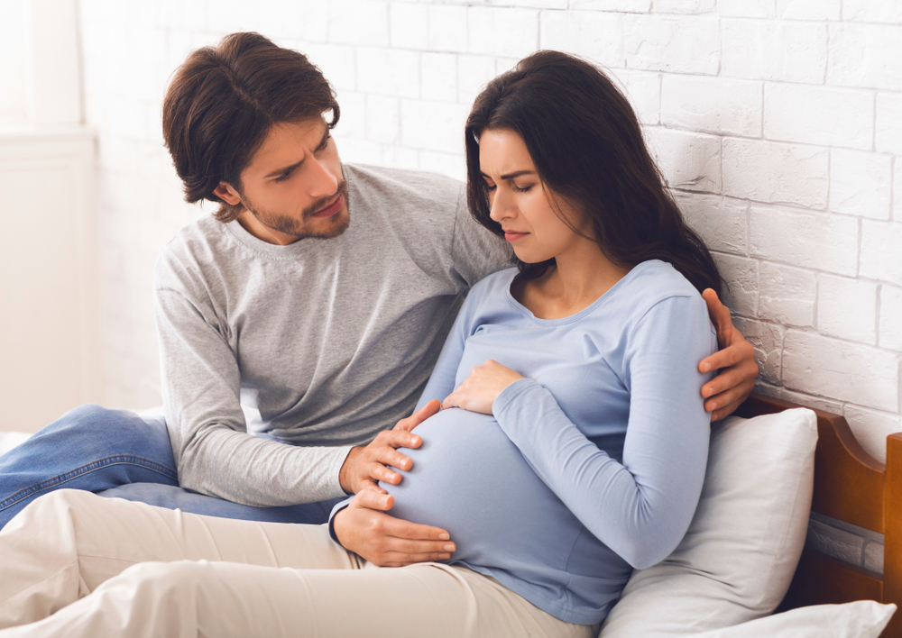 Valokuva, jossa raskaana oleva nainen ja mies.