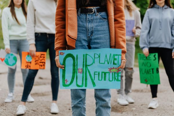 Kuvassa nuoria ja heidän kädessä kyltti, johon on kirjoitettu: our planet, our future.