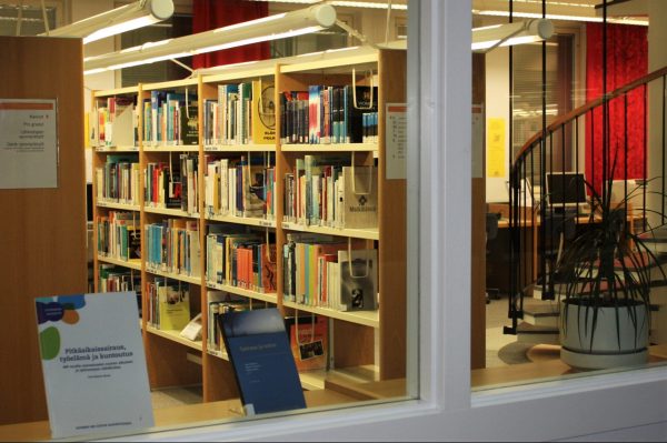 Valokuvassa kirjoja kirjastohyllyissä.