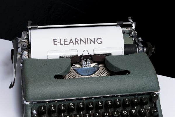Valokuvassa vanhan kirjoituskone ja sen paperissa teksti e-learning.