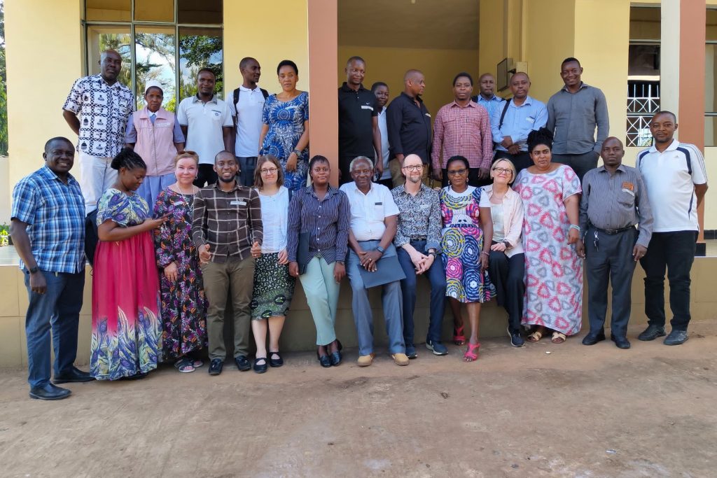 Finnish and Tanzanian people standing in a group for photo.