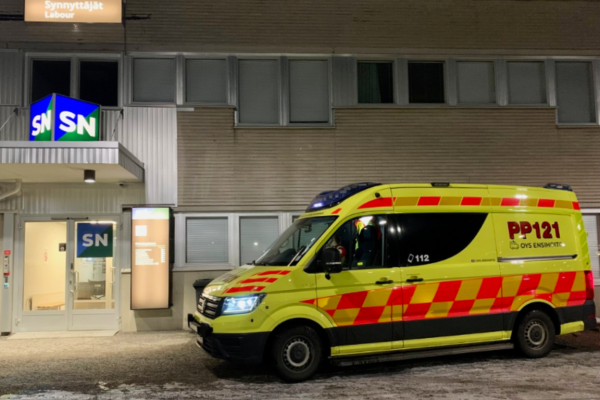 Valokuva ambulanssista sairaalan oven edessä, josta synnyttäjät ohjataan sisälle.